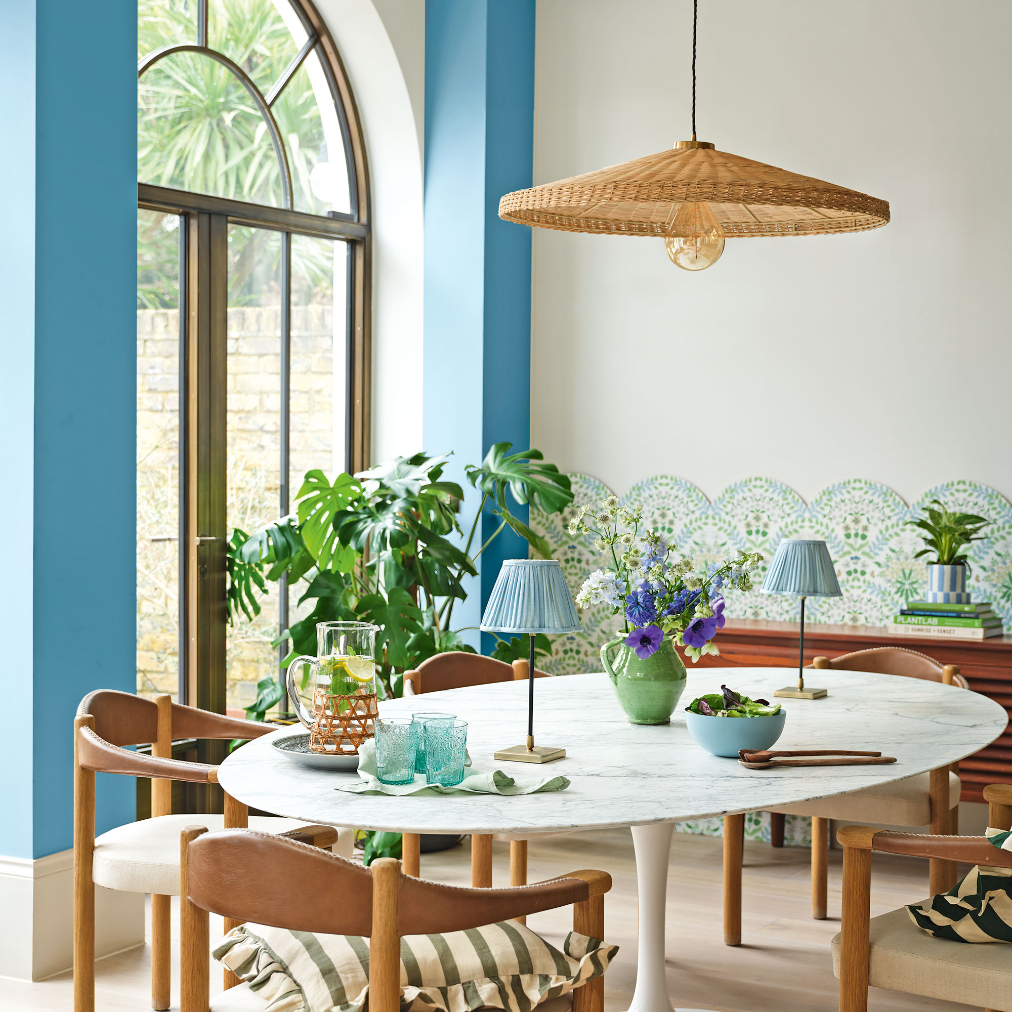 Blue living room with white oval table wooden chairs and blue lamps