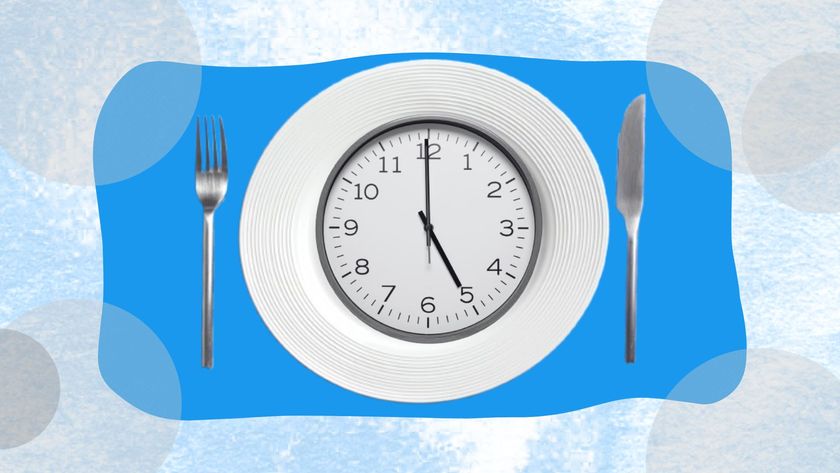 A dinner plate with a circular analogy clock inside it. The clock&#039;s face shows the time of 5pm. 