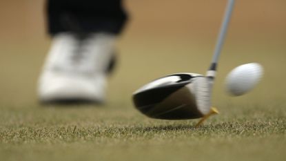 A golf club hitting a golf ball