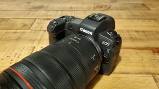 The lens attached to a Canon EOS R on a wooden desk