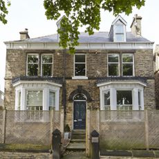 sloping roof house with exposed brick walls and white windows