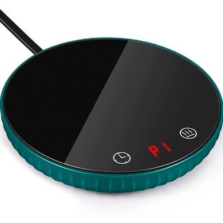 A product image of a round black mug warmer with a teal base