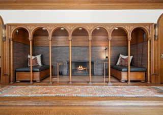 An inglenook fireplace with wooden arches and a long Persian style runner on the floor