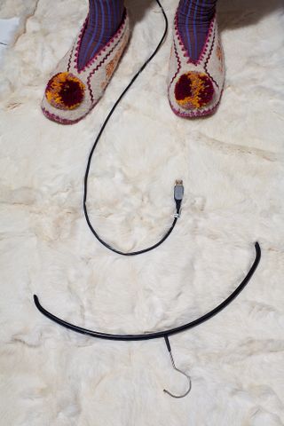 White marble floor with slippers, USB cable and clothing hanger on.