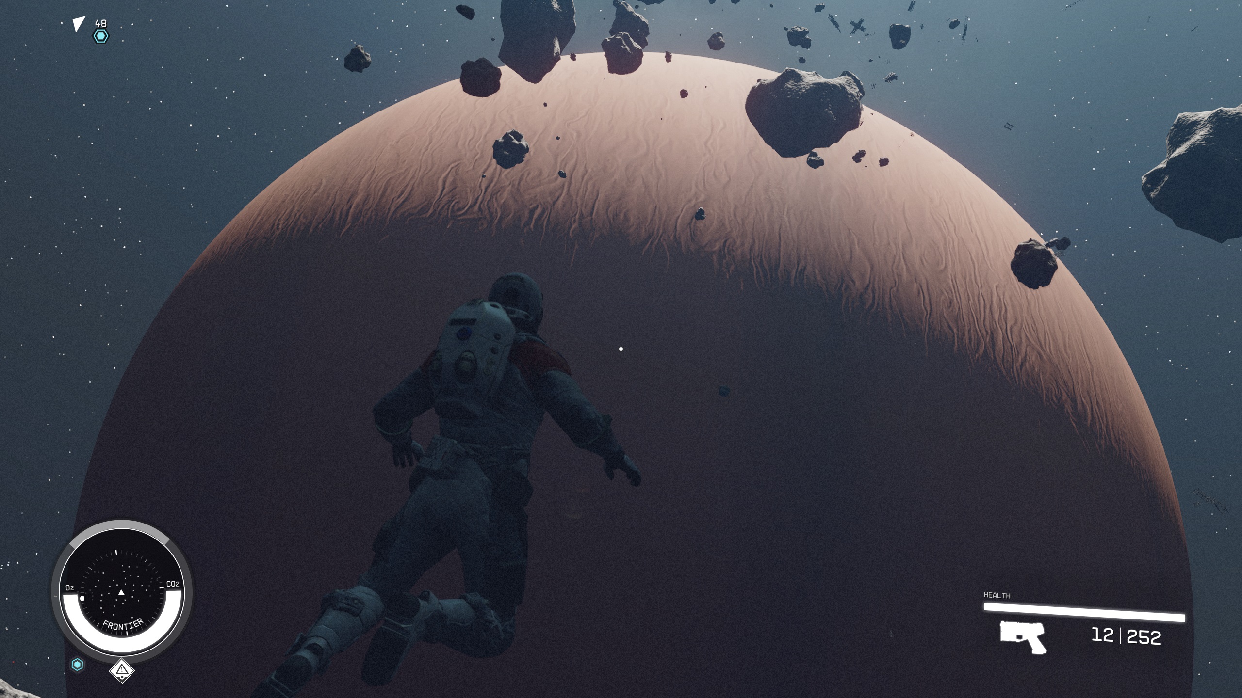 Starfield character in space suit floating amid asteroid field above gas giant