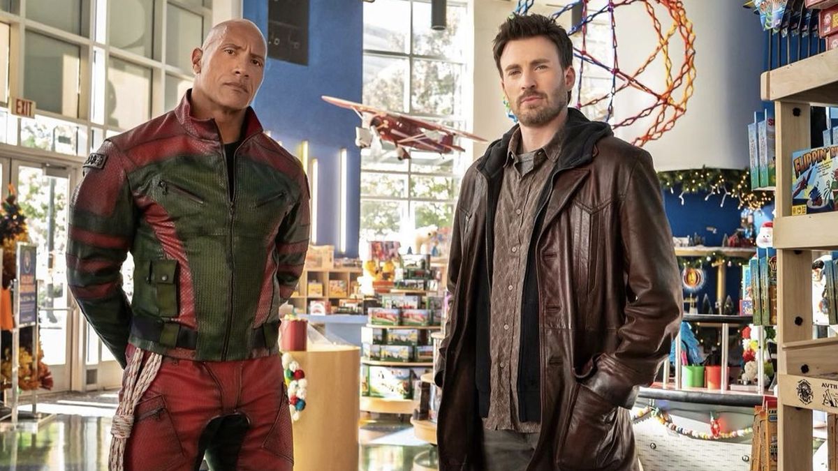 A press image for Red One, which shows Dwayne &#039;The Rock&#039; Johnson and Chris Evans standing in a foyer