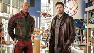 A press image for Red One, which shows Dwayne 'The Rock' Johnson and Chris Evans standing in a foyer