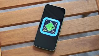 The Android 16 logo on a Google Pixel 8a outdoors.