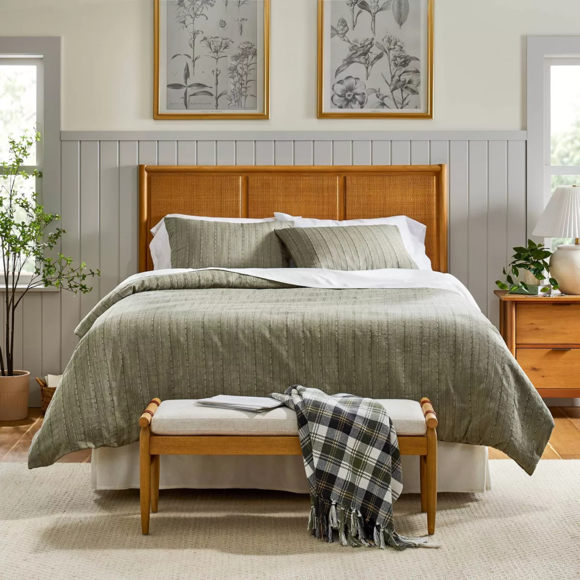 A sage green bedspread in a light gray bedroom