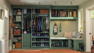 boot room area with green furniture and doors open to show racks of shelving with coats, shoes and boots