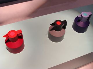 Three jugs with large barrels style bases. One in red, one in brown and black, one in dark brown and brown.