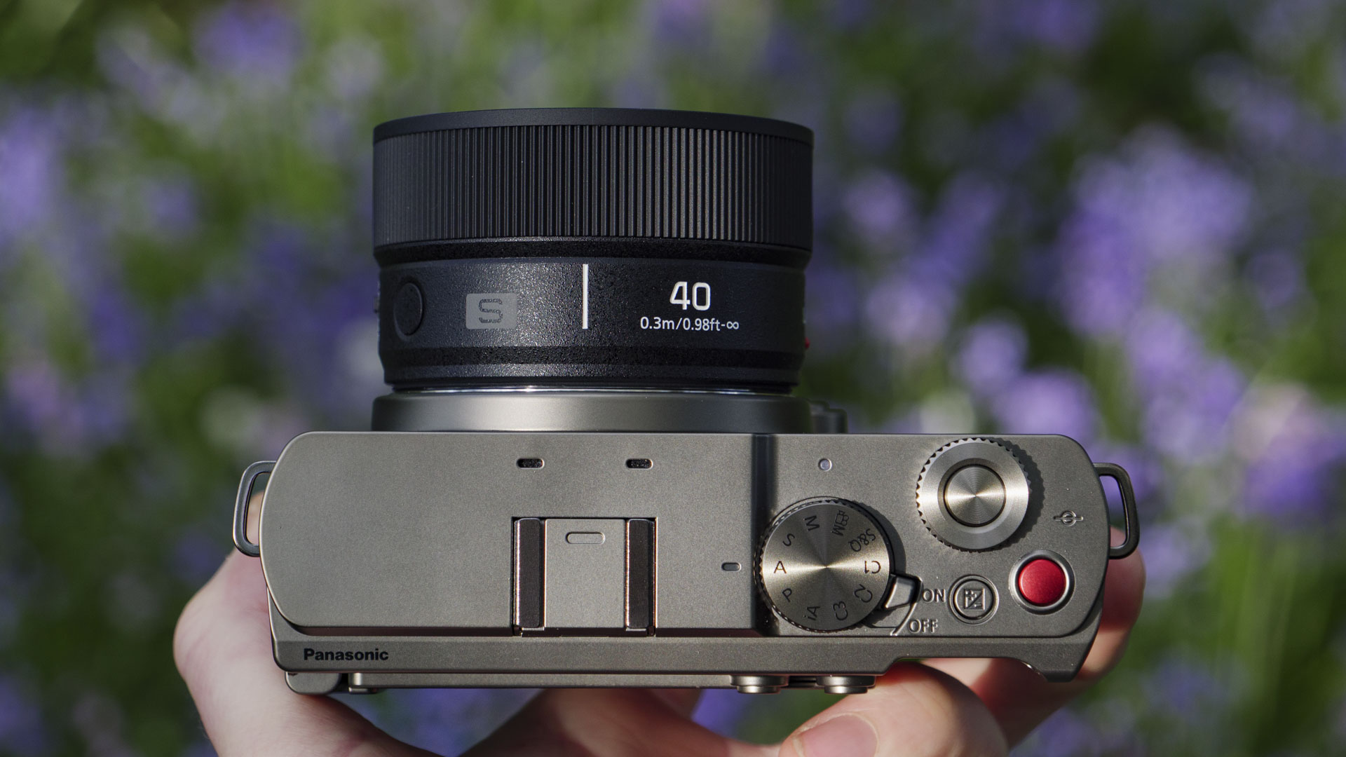 The Panasonic Lumix S 40mm F2 lens attached to a 'titanium' version of the Lumix S9, with natural bluebell backdrop