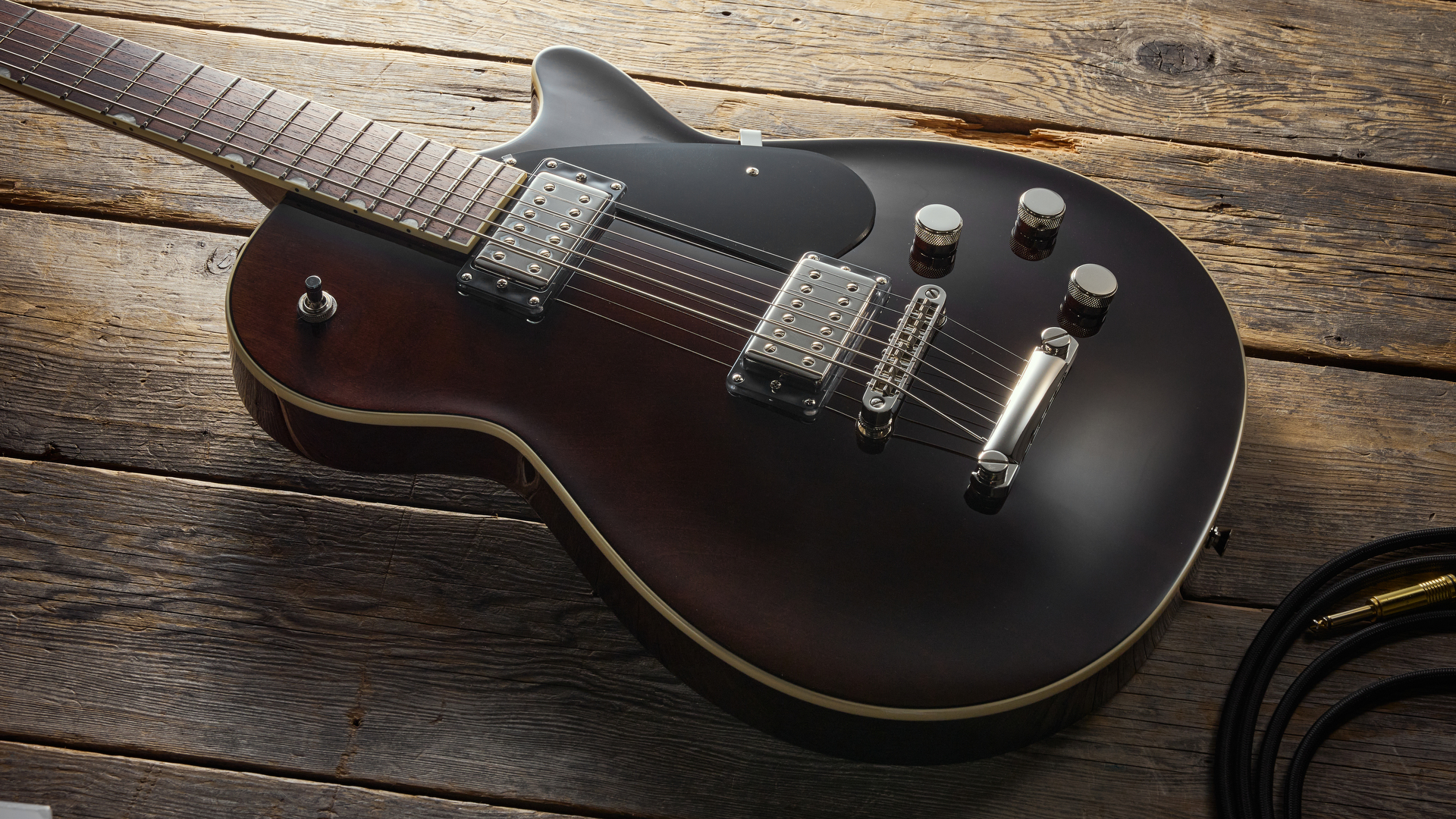 A Gretsch Electromatic Jet Baritone guitar on a wooden floor