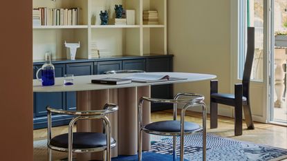 a dining room with metal tables and a sculptural black chair