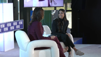 Asha Sharma speaks on stage during a Fortune Conversations interview, discussing Xbox's Project Helix strategy while seated in a white chair opposite the event moderator.