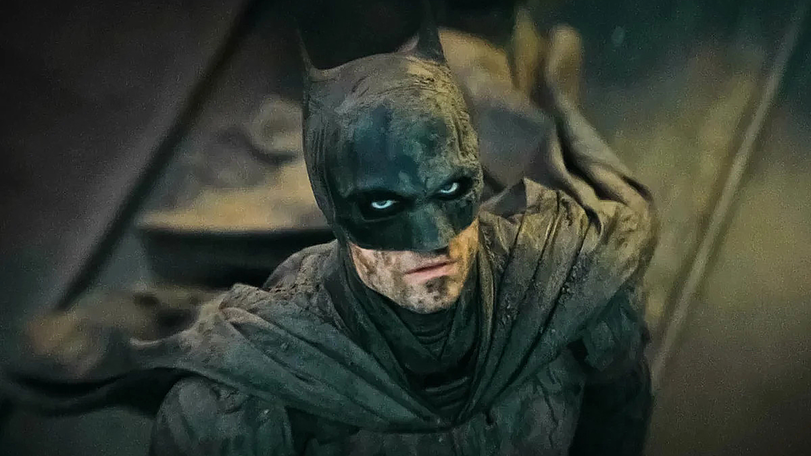 Robert Pattinson's mud-covered Caped Crusader looking up in The Batman