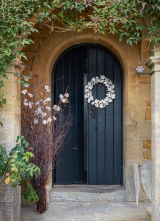 Dark blue door with white metal wreath