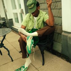tyler the creator wear green button down, brown slacks, hat, and green converse jogger sneaker