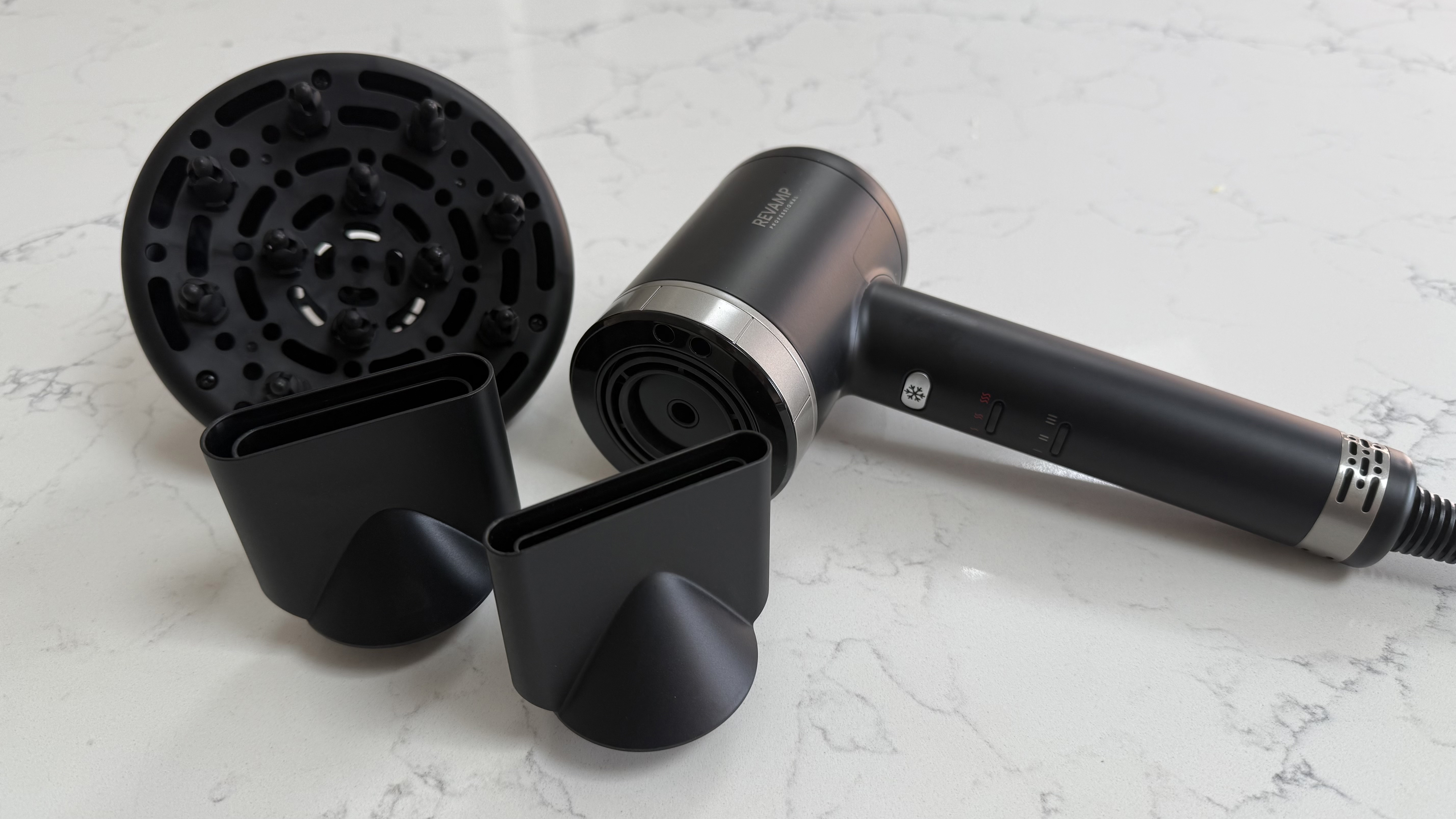 Diffuser and two concentrator nozzles displayed next to the Revamp Tri-Care hair dryer