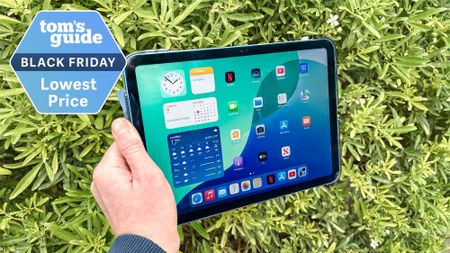 iPad 11 in hand with bushes in background with Black Friday deal badge