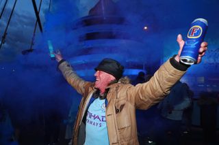 A jubilant Manchester City fan celebrates his club regaining the Premier League title by lighting a flare outside the Etihad Stadium. City were confirmed champions on May 11 after second-placed Manchester United were beaten 2-1 at home by Leicester. Glory for Pep Guardiola's side, who are set to lift the trophy in front of 10,000 supporters after hosting Everton on Sunday, was their third title success in four seasons