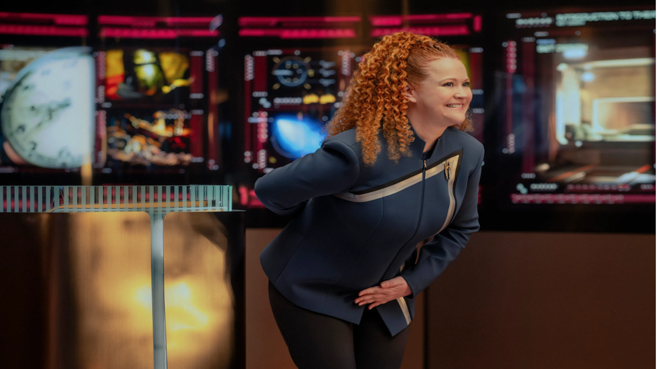 uma mulher com laços de cabelo ruivos vestindo um uniforme azul de ficção científica