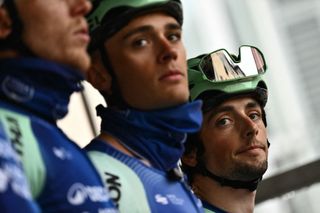 Victor Lafay (R) of team Decathlon - AG2R stands on stage with teammates before the start of the Milan - Sanremo one-day classic cycling race, in Pavia, near Milan, on March 22, 2025. (Photo by Marco BERTORELLO / AFP)