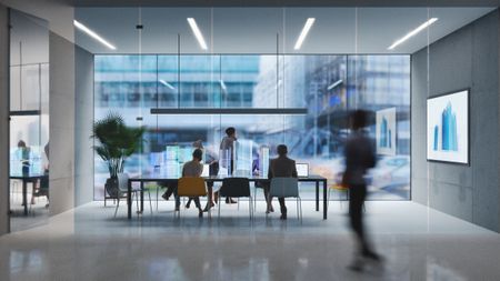 Workers gather around a desk in a futuristic office