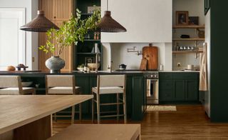 an open plan kitchen in dark green