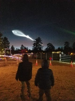 Skywatcher Jennifer Garrison and her two sons Nicholas, 8, and Ethan, 5, observe SpaceX's dazzling rocket launch from their location in Big Bear, California on Dec. 22, 2017.