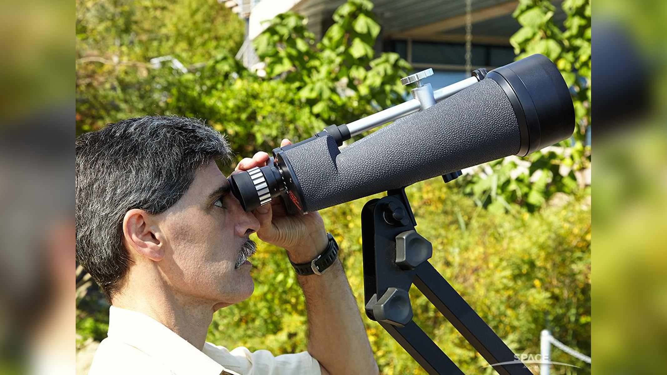 Celestron Skymaster 25x100 binoculars in use with author looking through them at the moon
