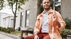 a blind man sits on a park bench