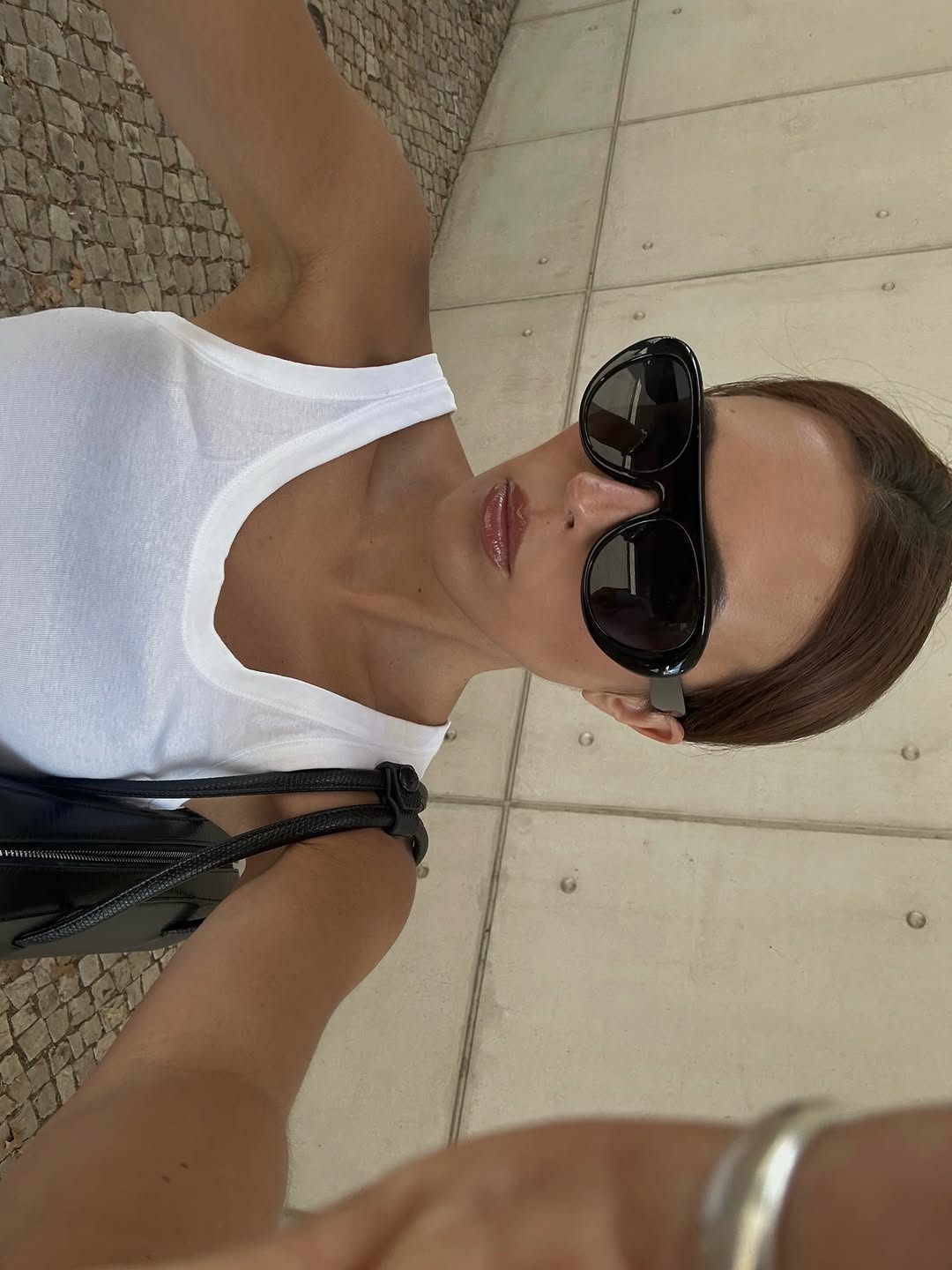 An image of woman wearing shield sunglasses, one of the biggest early summer 2026 micro trends.