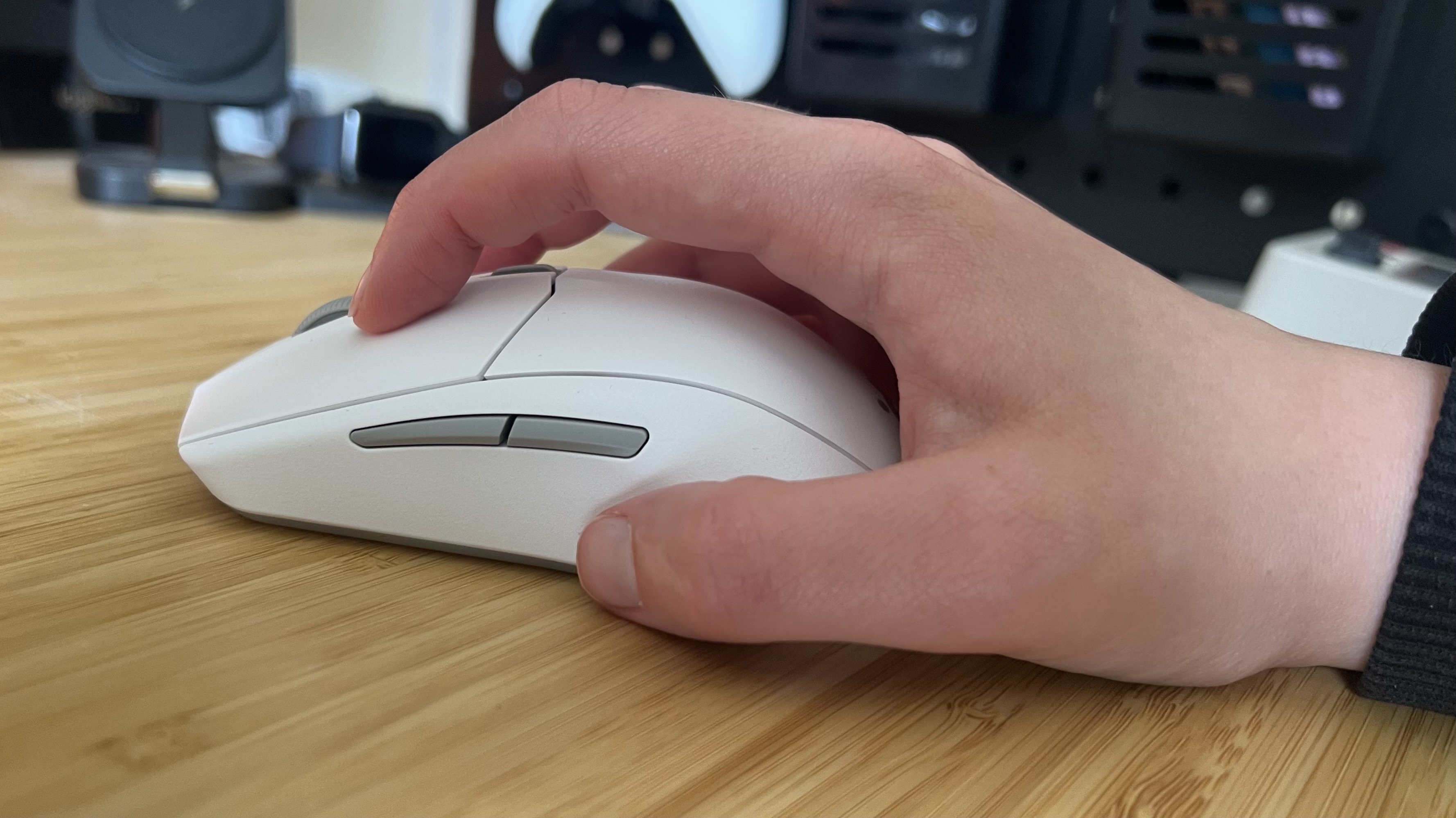 Hand using the SteelSeries Rival 3 Wireless Gen 2 in a claw grip on a wooden desk