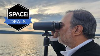 A man looking through the Unistellar Envision smart binoculars with a sunset in the background, with a black Space.com deals badge in the upper left corner. 