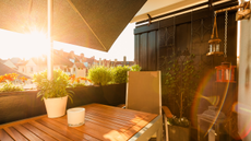 Small balcony with plants and sunshade in urban area