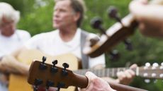 Older musicians playing folks or traditional music together outdoors.