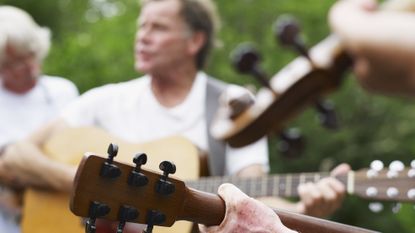 Older musicians playing folks or traditional music together outdoors.