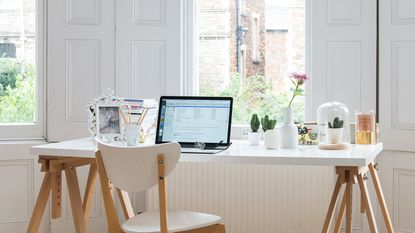 Desk area in front of windows with wooden shutters