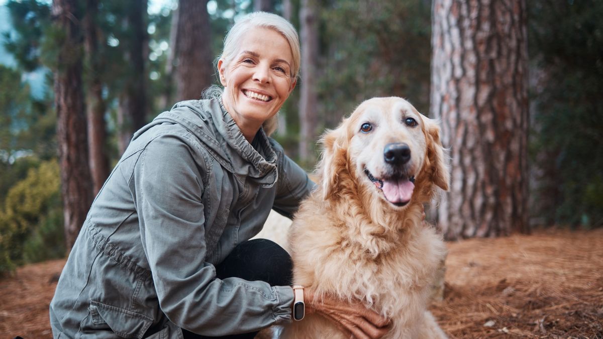 Woman and her golden retriever in the woods