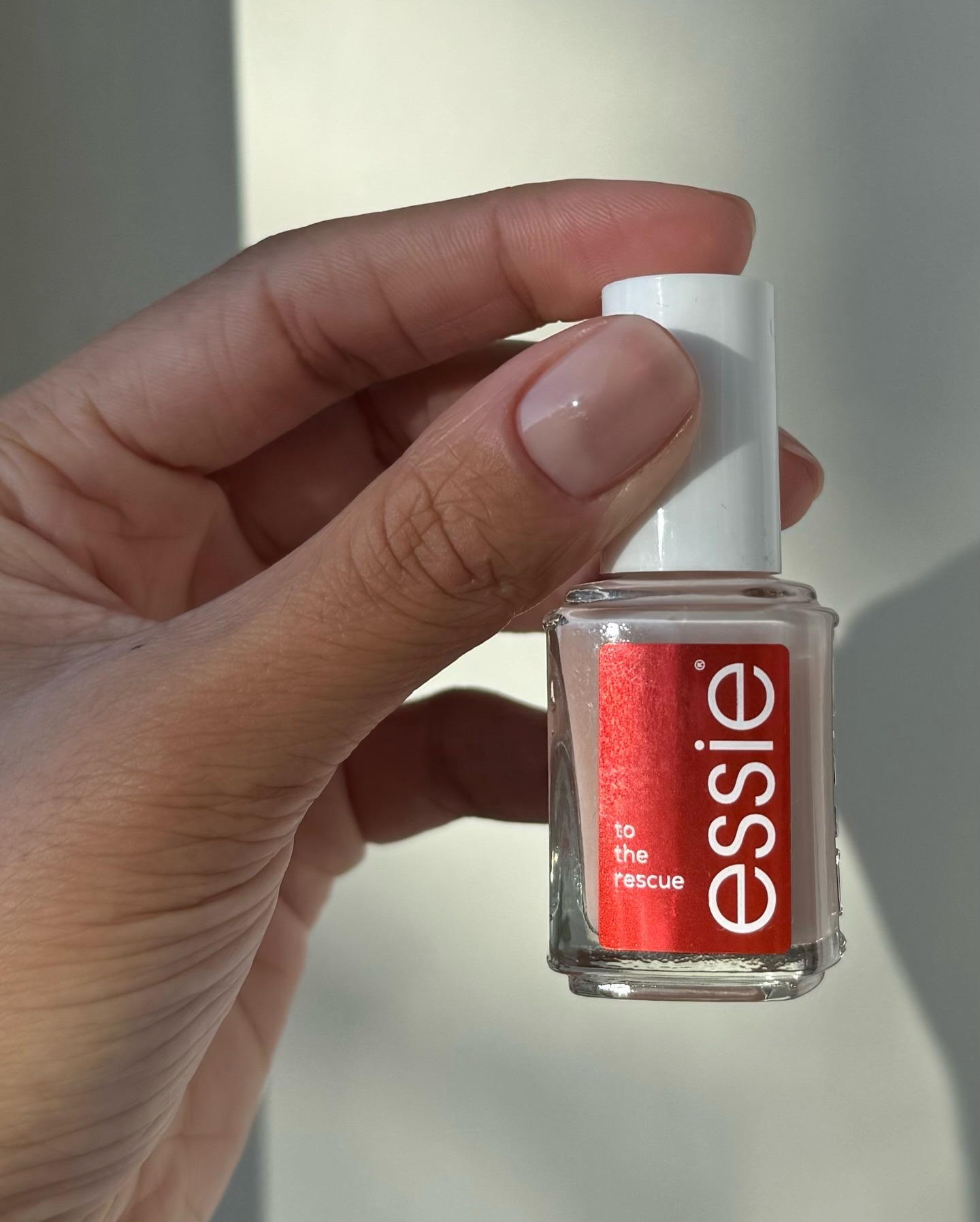 @iramshetlon holding a bottle of Essie to the rescue nail polish