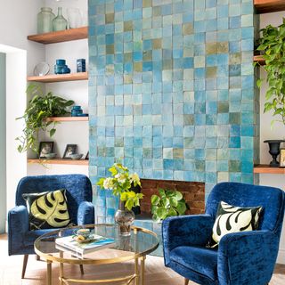 Living room with green tiled chimney breast with two blue armchairs on either side
