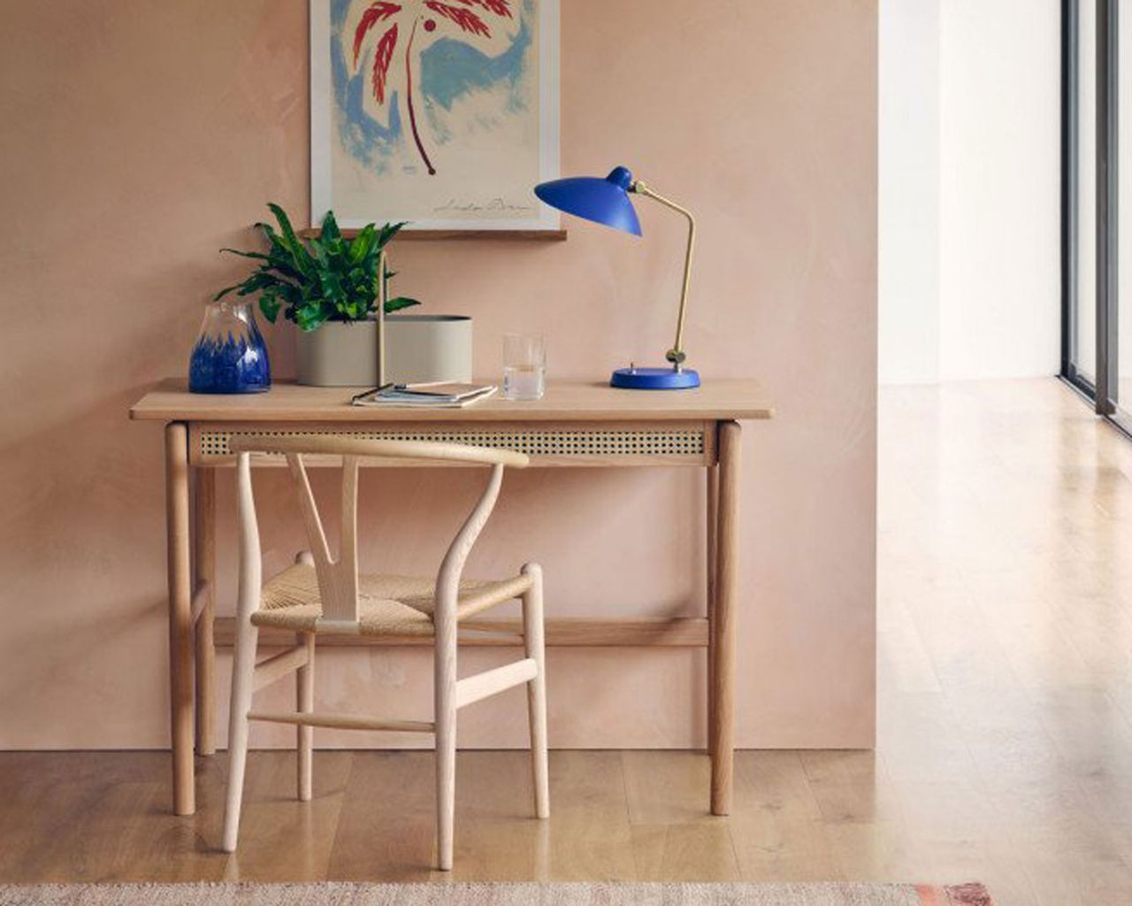 brass and cobalt blue desk light with wooden desk and plaster effect walls