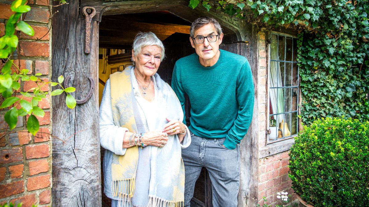 Louis Theroux and Dame Judi Dench stand together in a doorway.