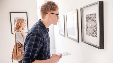 Young couple looking at photographs at gallery