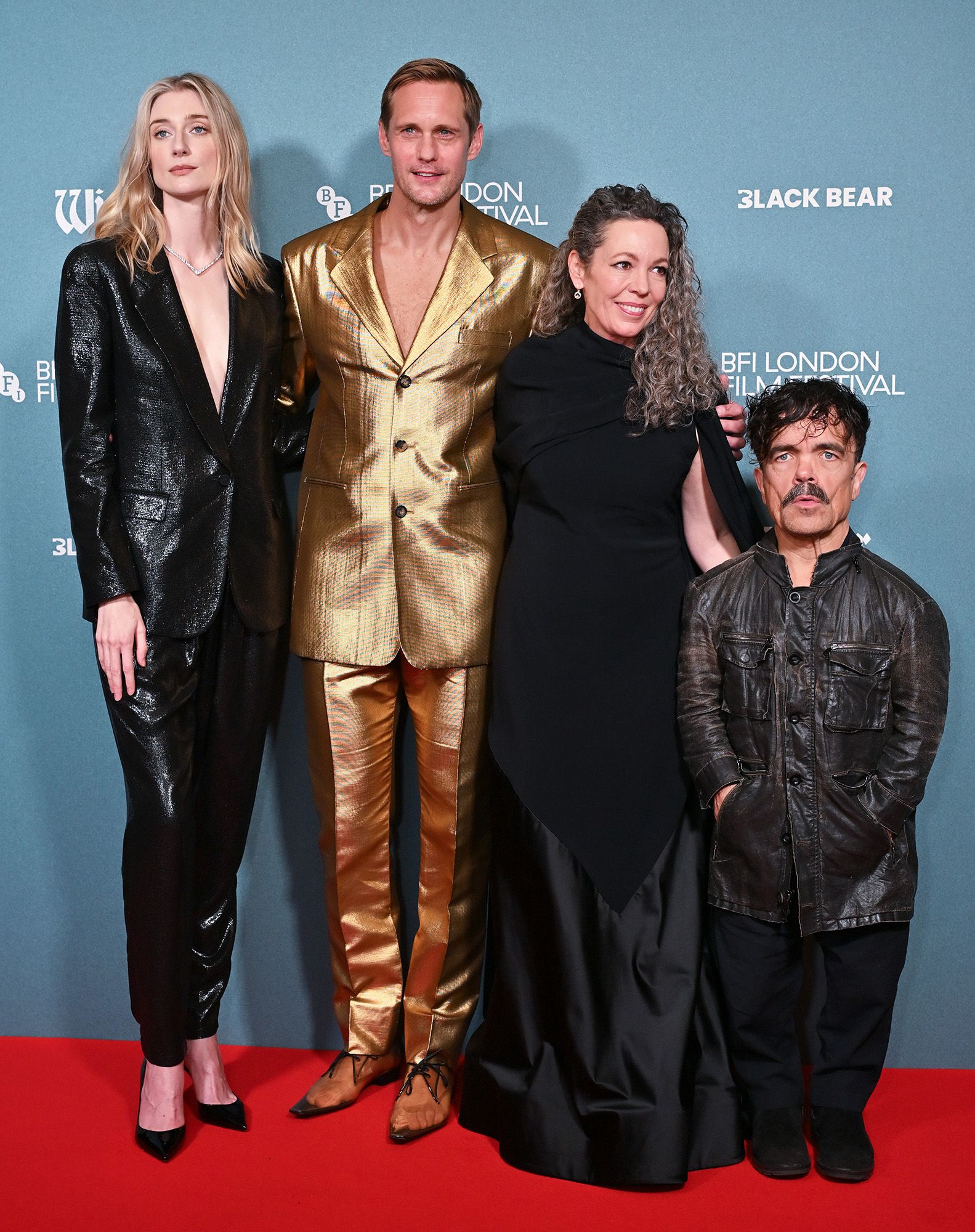Elizabeth Debicki, Alexander Skarsgard, Olivia Colman and Peter Dinklage pose on Wicker BFI red carpet. Skarsgard is in gold and the rest of the cast wears black.