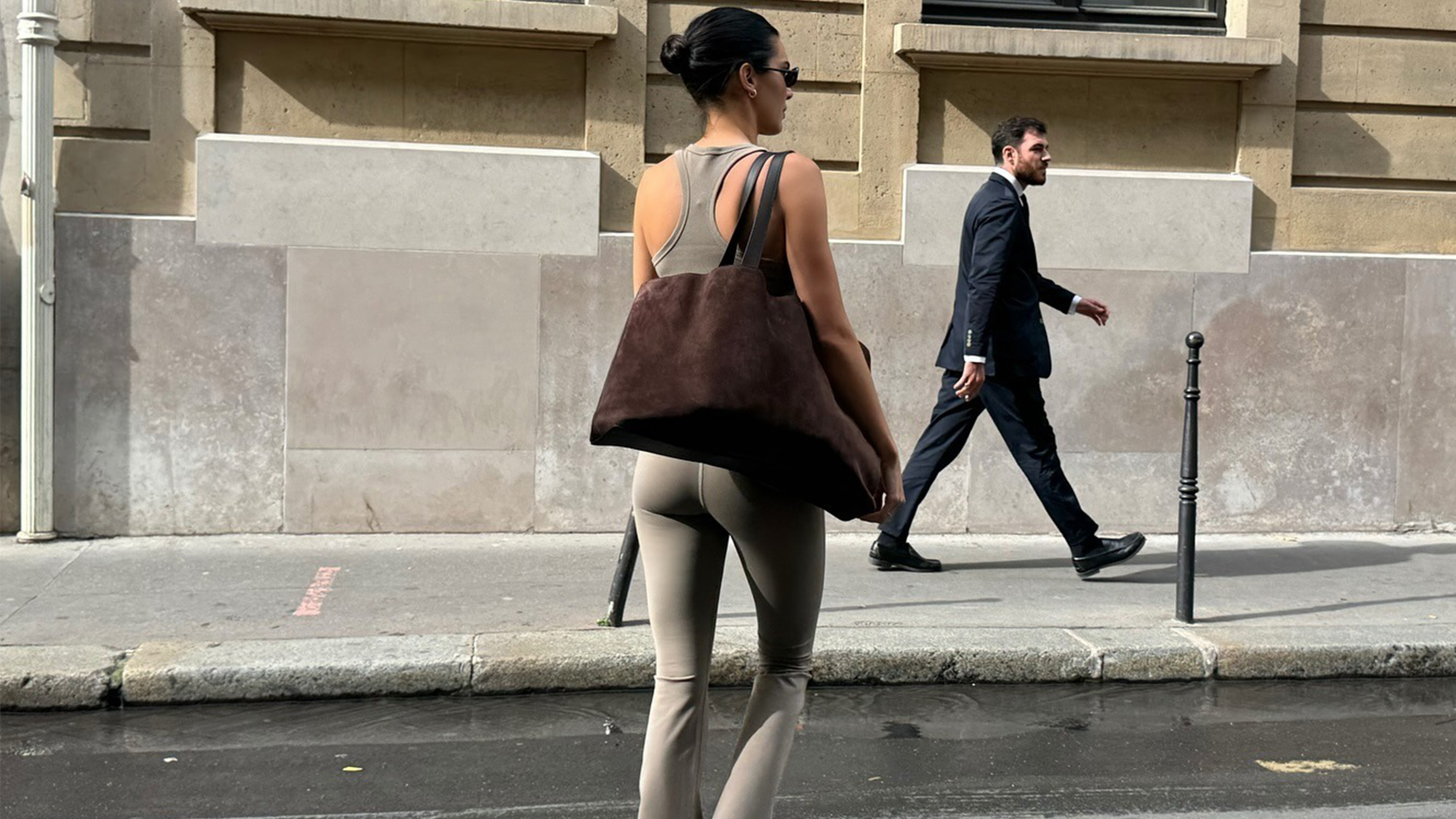 Kendall jenner wears a taupe tank top, brown suede tote bag, and taupe leggings.