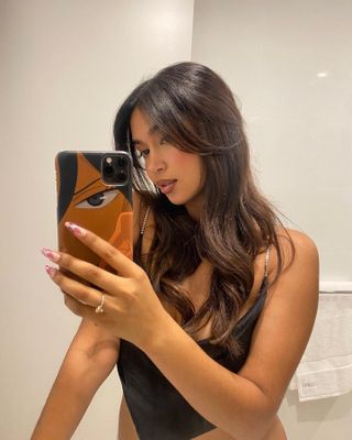 Mishti Rahman taking a mirror selfie with long, flowing hair