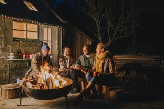 people gathered round a fire pit in the winter
