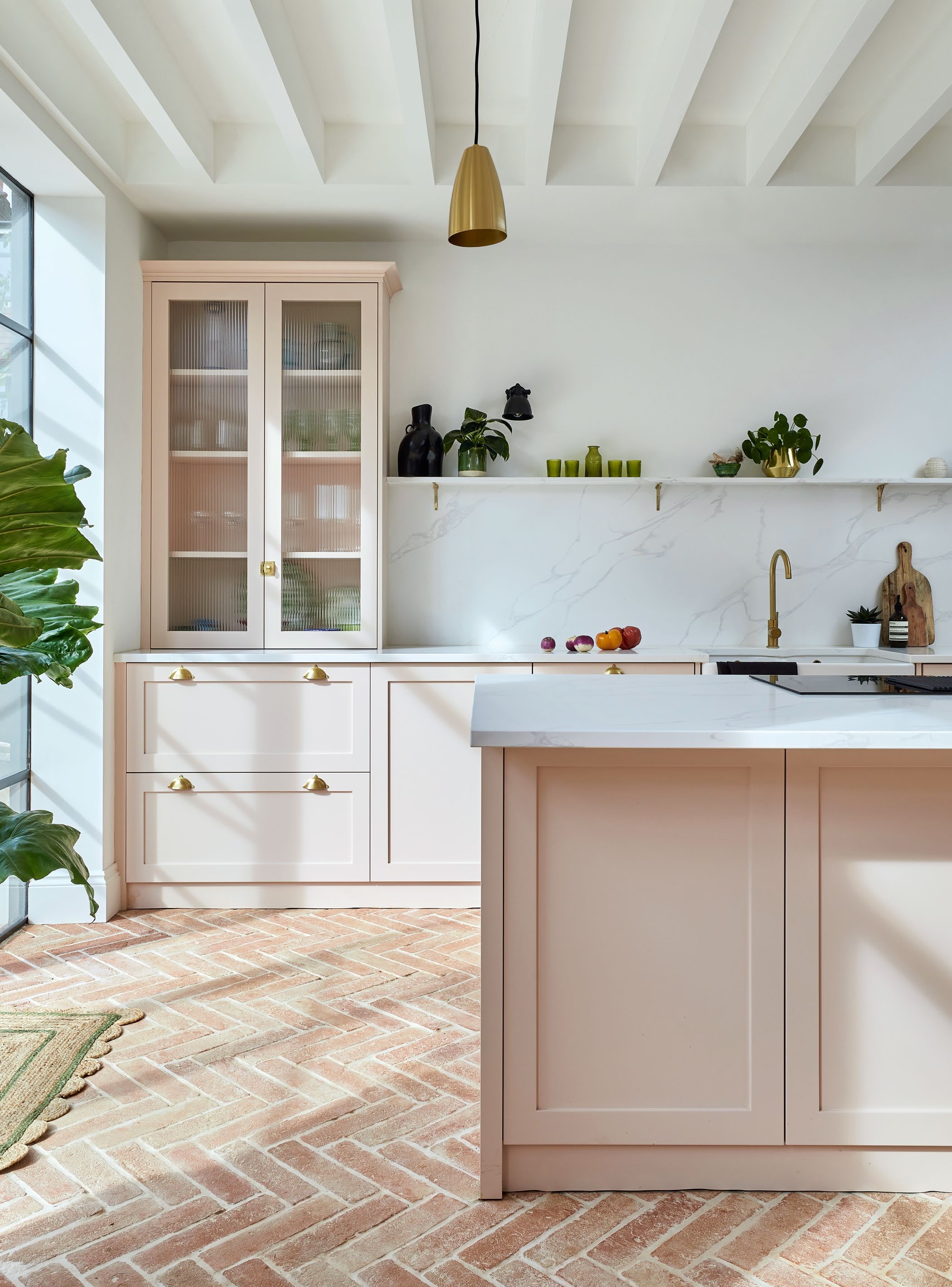 White kitchen walls, pink cabinets and terracotta flooring